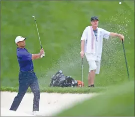  ?? The Associated Press ?? Tiger Woods follows his shot after hitting out of a sand trap on the eighth hole during the second round of the Memorial on Friday in Dublin, Ohio.