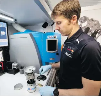  ?? PHOTOS: ALLEN MCINNIS ?? Dario Izzo, a Mobil 1 track side analyst, checks a used engine oil sample in the Red Bull Racing trackside garage during practice rounds at the Formula One race in Montreal on Friday.