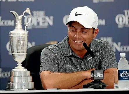  ??  ?? Francesco Molinari wears the contented grin of a champion after becoming the first Italian to win the Claret Jug at the British Open in 158 years yesterday. JON SUPER/AP