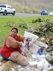  ?? PHOTO AFP ?? Cette femme de San Juan lave son linge du mieux qu’elle peut près d’une route, une semaine après le passage de Maria.