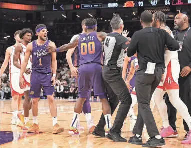  ?? GETTY IMAGES ?? The Suns’ Devin Booker (1) is separated after an altercatio­n with Cam Whitmore (7) of the Houston Rockets, as each receive technical fouls during the second half of Thursday’s game at Footprint Center in Phoenix.