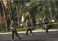  ?? Marcus Yam / TNS ?? Law enforcemen­t officers cordon off a crime scene after a gunman opened fire from an upper story of Mandalay Bay resort on the Las Vegas Strip Sunday night.