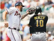  ?? JOHN BAZEMORE/ASSOCIATED PRESS ?? The Pirates’ Jordy Mercer is safe at first as the Braves’Matt Adams loses the handle on the ball.