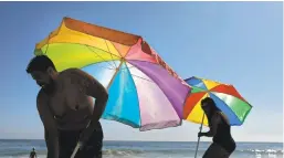  ?? JAE C. HONG/AP ?? Beach umbrellas may be needed even more in the near future.