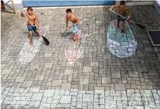  ??  ?? Rafael, 10, David, 10, und Linus, 10, aus Kaufering träumen von einem Stand up Paddle Brett. Wie man auf solch einem Wassergefä­hrt steht, wissen die drei schon aus dem Effeff – wie sie auf den gemalten Brettern zeigen.