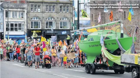  ??  ?? > Extinction Rebellion protesters move their boat at the end of the Cardiff demonstrat­ion last month