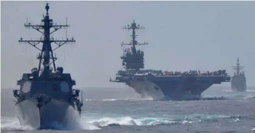  ??  ?? Le porte-avions George Washington escorté par un destroyer Arleigh Burke et un croiseur de classe Ticonderog­a, en mer de Timor, en 2016. (© US Navy)