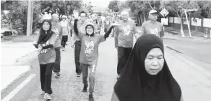  ??  ?? NYAGA PENGERAI: Lee (baris dua, dua kiba) enggau Adam (dua kanan) begulai enggau orang tuai bejalai bebala mayuh ari palan sida ngelawa Lorong 9, sebedau mulaika diri baru ngagai palan nya.