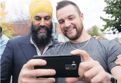  ?? JACQUES BOISSINOT/THE CANADIAN PRESS ?? NDP Leader Jagmeet Singh, left, poses for a photo with resident Mathieu Dallaire, during a campaign visit for local candidate Gisele Dallaire, Tuesday in Alma Que.