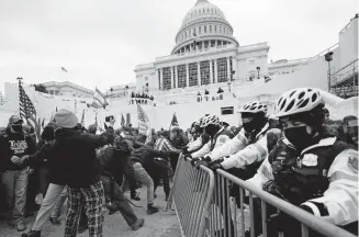  ?? CORTEZ/ THE ASSOCIATED PRESS] [JULIO ?? Trump supporters try to break through a police barrier, Wednesday at the Capitol in Washington.