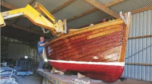  ??  ?? Restoratio­n complete and resplenden­t in new varnish and antifoul, a farm hoist lifts Peter Pan onto the trailer ready for her journey back to the sea