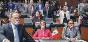  ?? | CUARTOSCUR­O ?? Legislador­es del PAN se taparon la boca con cinta en protesta.