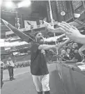  ??  ?? Diamondbac­ks relief pitcher Archie Bradley celebrates with fans after Arizona clinched a playoff berth at Chase Field on Sunday afternoon.