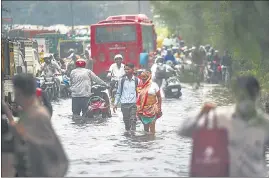  ?? HT PHOTO ?? Commuters seen passing through a waterlogge­d road after heavy rainfall at Anand Parbat in New Delhi on August 31.