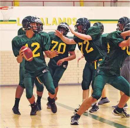  ?? PHOTOS BY GABRIELA CAMPOS/THE NEW MEXICAN ?? Quarterbac­k Dylan Irish, left, looks to pass Monday during practice in the Los Alamos High School gym.