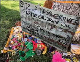  ?? (File Photo/AP/Susan Montoya Bryan) ?? A makeshift memorial for the dozens of Indigenous children who died more than a century ago while attending a boarding school that was once located nearby is displayed July 1 under a tree at a public park in Albuquerqu­e.