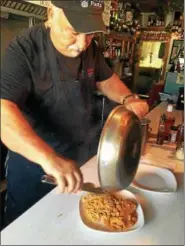  ?? JANET PODOLAK — THE NEWS-HERALD ?? JP, as Gianpiero Piras is known by his many friends, plates a dinner at the counter of his popular Geneva-on-the-Lake restaurant.