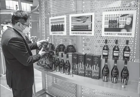  ?? PROVIDED TO CHINA DAILY TANG KE / FOR CHINA DAILY ?? Above: A visitor checks out Pernod Ricard products during the fifth China Internatio­nal Import Expo in Shanghai in November.
Left: Visitors gather at Changyu’s booth during an internatio­nal wine expo in Yantai, Shandong province.