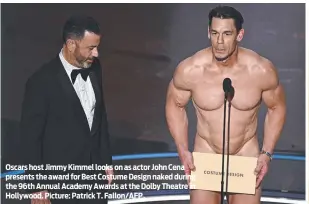  ?? ?? Oscars host Jimmy Kimmel looks on as actor John Cena presents the award for Best Costume Design naked during the 96th Annual Academy Awards at the Dolby Theatre in Hollywood. Picture: Patrick T. Fallon/AFP