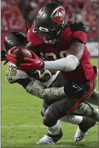  ?? (AP/Mark LoMoglio) ?? Tampa Bay Buccaneers running back Rachaad White dives into the end zone for a touchdown as New Orleans Saints linebacker Demario Davis (Arkansas State) defends in the fourth quarter Monday night at Raymond James Stadium in Tampa, Fla. The Buccaneers defeated the Saints 17-16 to remain on top of the NFC South.