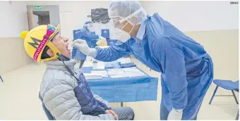  ?? XINHUA ?? TEST. Un trabajador de la salud toma una muestra a un jinete en las instalacio­nes del Hipódromo de las Américas, en la Ciudad de México.