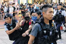  ?? TYRONE SIU • REUTERS ?? Police detain a woman with paper flowers June 4 on the 34th anniversar­y of the 1989 Beijing’s Tiananmen Square crackdown, near where the candleligh­t vigil is usually held, in Hong Kong, China.