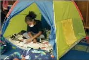  ?? CHARLIE RIEDEL - THE ASSOCIATED PRESS ?? Fifth grader Jordan Falconbury reads inside a tent while visiting a sensory room at Quincy Elementary School, Nov. 3, in Topeka, Kan. The rooms are designed to relieve stresses faced by students as they return to classrooms amid the ongoing pandemic.