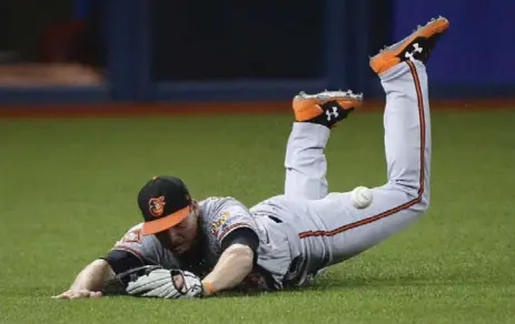  ?? NATHAN DENETTE/THE CANADIAN PRESS ?? The Orioles’ Trey Mancini can’t snag this RBI double by Jays’ Richard Urena Wednesday night at the Rogers Centre. The Orioles won the series finale, 2-1.