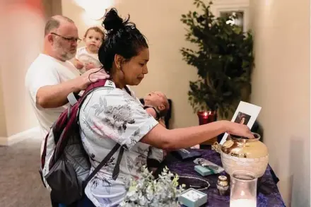  ?? Photos by Jessica Phelps/staff photograph­er ?? Janel Rodriguez reaches into the urn her family chose so she can touch the remains of her son Noah, 15, who died Aug. 21.