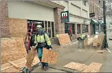  ?? BLOOMBERG ?? Workers board up businesses following an FBI warning on protrump protests ahead of the inaugurati­on, in Michigan.