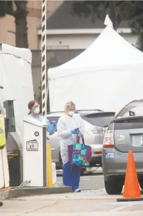  ?? Lea Suzuki / The Chronicle ?? Medical staff work in March at a coronaviru­s testing site at a parking lot at the CPMC Sutter Health California campus in San Francisco.