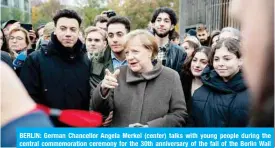  ??  ?? BERLIN: German Chancellor Angela Merkel (center) talks with young people during the central commemorat­ion ceremony for the 30th anniversar­y of the fall of the Berlin Wall yesterday at the Berlin Wall Memorial at Bernauer Strasse in Berlin. — AFP