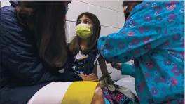  ?? SHAWN ROCCO — DUKE HEALTH ?? Alejandra Gerardo, 9, looks up to her mom, Dr. Susanna Naggie, as she gets the first of two Pfizer COVID-19 vaccinatio­ns during a clinical trial for children at Duke Health in Durham, N.C., on Wednesday.