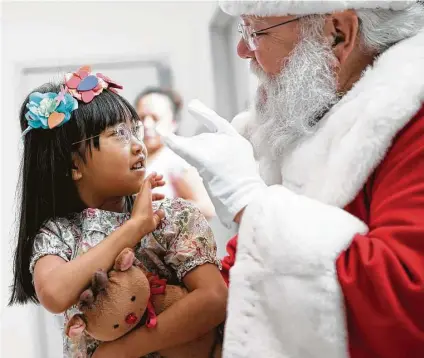  ?? Elizabeth Conley / Houston Chronicle ?? Knots Hasegawd, 5, has a chat with Santa after getting her photo taken with him Saturday at the Children’s Museum of Houston.