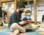  ?? ?? Dayne Kemereley, 10, left, and Gavin Connolly, 11, work in their fifth grade math class Wednesday at St. Benedict Catholic School.