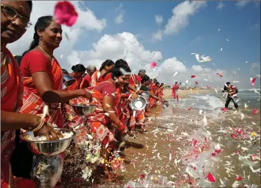  ?? REUTERS ?? Women scatter flower petals in the waters of the Bay of Bengal during a prayer ceremony for the victims of the 2004 tsunami on the 15th anniversar­y of the disaster, at Marina beach in Chennai on Thursday.