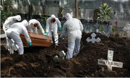  ?? Photograph: José Cabezas/Reuters ?? Cemetery workers inter the coffin of a woman who died from Covid-19 at the Santa Tecla cemetery in El Salvador on 24 June 2020.