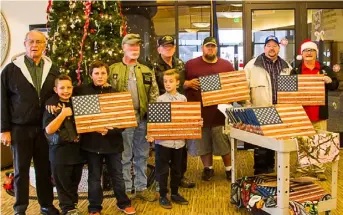  ?? Photos: Ed Helmick ?? Left: Flags given to WWII Veterans. Right: Volunteers donate flags to Veterans at the Bennion Central Utah Veterans Home.