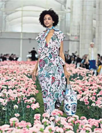  ??  ?? A model makes her way along Tory Burch’s carnation garden catwalk during New York Fashion Week