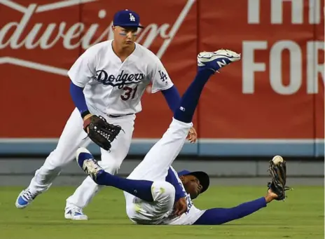  ?? JAYNE KAMIN-ONCEA/GETTY IMAGES FILE PHOTO ?? With Dodgers teammate Joc Pederson looking on, Curtis Granderson makes a sliding catch. Granderson is expected to be part of a platoon for the Jays.