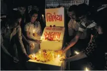  ?? SAM PANTHAKY/AFP/GETTY IMAGES ?? Indians light candles during a memorial on the eve of the one-year anniversar­y of the gang rape and murder of a 23-year-old student.