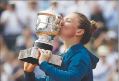  ?? Associated Press photo ?? Romania's Simona Halep kisses the trophy as she celebrates winning the final match of the French Open tennis tournament against Sloane Stephens of the U.S. in three sets 3-6, 6-4, 6-1, at the Roland Garros stadium in Paris, France, Saturday.