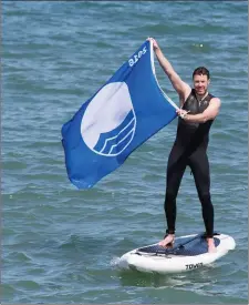  ??  ?? Ciaran Duggan takes to the water to mark the announceme­nt of this year’s Blue Flag and Green Coast recipients.