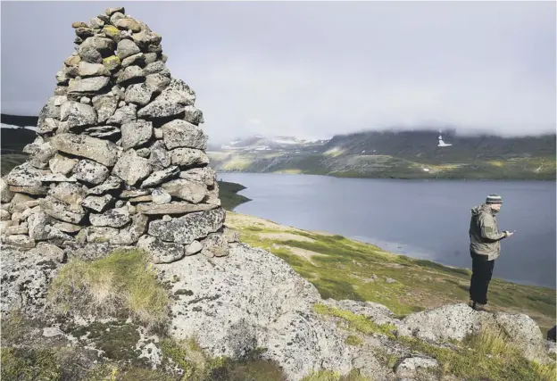  ?? PICTURE: EGILL BJARNASON ?? 0 An Icelandic environmen­t agency ranger attempts to get a signal on the unofficial­ly named Telephone Mountain in the country’s remote north-west