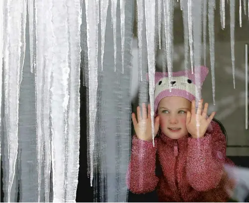  ?? PICTURE: ANDREW MILLIGAN/PA ?? Karis Milligan, 6, looks at icicles from her grandparen­ts’ house in Dunblane as the bad weather continues.