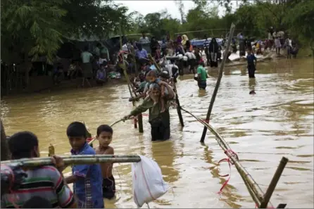  ?? BERNAT ARMANGUE, THE ASSOCIATED PRESS ?? Rohingya Muslims who crossed from Myanmar into Bangladesh are forced to find alternativ­e shelter after their refugee camp was flooded.