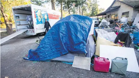  ??  ?? Tents and belongings are moved from the encampment at a private rural site on West Saanich Road.