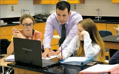  ?? Shaler Area School District ?? Physics teacher Greg Mason works with students at Shaler Area High School. He is one of four teachers in Allegheny County who have been nominated for 2018 Pennsylvan­ia Teacher of the Year.