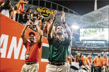  ?? COURTESY OF 247 SPORTS ?? Manny Diaz II, Miami’s defensive coordinato­r (right), and his father, Manny Diaz, the former mayor of Miami, celebrate and acknowledg­e the fans after the Hurricanes’ 41-8 victory over Notre Dame.