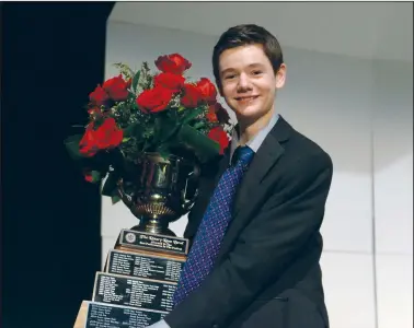  ?? NEWS PHOTO MO CRANKER ?? Rose Bowl winner Soren Lorentzen stands with his trophy and a number of roses Sunday evening at the Medicine Hat College Theatre. The Grade 10 Monsignor McCoy student won the grand prize for his strings performanc­es.